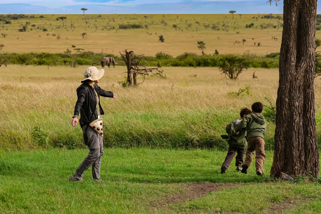 Bambini con la guida nella savana, con gli elefanti sullo sfondo