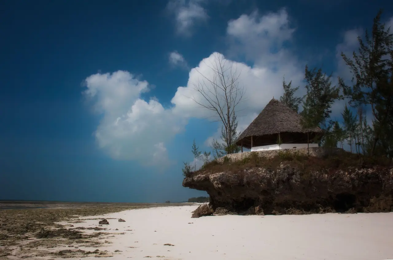 Spiaggia bianca di Zanzibar con una capanna sulla roccia